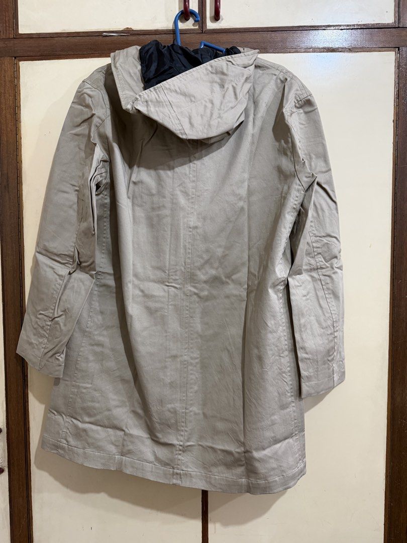 GU Beige Hooded Long Coat Jacket with Pockets Medium (Category: Coats, Jackets and Outerwear) located in Manila. Submitted by preloved_new_forsale (Listing ID 1465920304, Image 2). Description: - Color: Beige with contrasting black inner lining - Closure: Front zipper and button closure - Pockets: Two large front flap pockets for ample storage - Length: Long sleeves and extended hem hitting past the hips - Condition: Clean fabric with visible fol