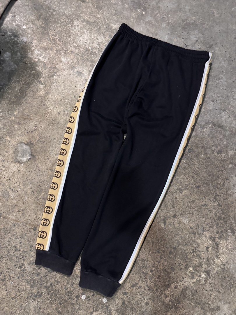 Gucci Black Sweatpants with Interlocking G Side Stripes (Category: Joggers) located in Pasig City. Submitted by dripthrift1600 (Listing ID 1465949464, Image 2). Description: - Authentic Gucci sweatpants in classic black fleece - Elastic waistband with adjustable drawstring closure - Signature tan side stripes with iconic interlocking G monogram and white piping - Comfortable cuffed ankles and casual fit - Premium clean cotton blend material - Mad
