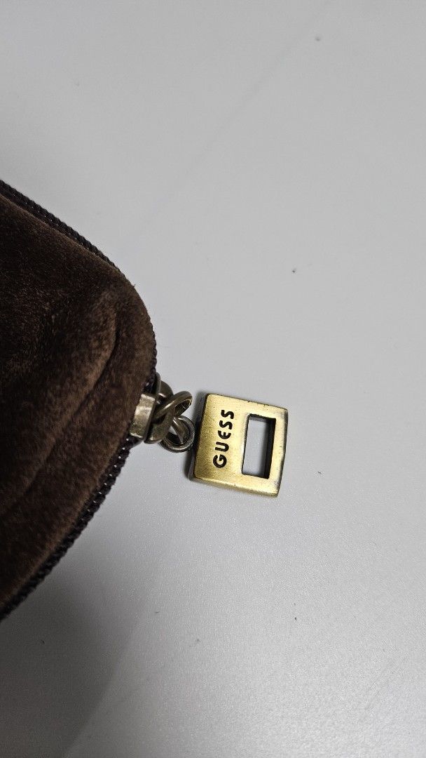 Guess Brown Suede Coin Purse Pouch (Category: Purses & Pouches) located in Alfonso. Submitted by jbcamet (Listing ID 1465923943, Image 2). Description: - Brand: Guess - Material: Real leather suede exterior with polyester lining - Color: Brown with brass hardware - Closure: Secure zipper with Guess logo pull - Features: Rectangular shape, front Guess logo plaque, and interior key ring - Condition: Great for organizing loose change and small essen