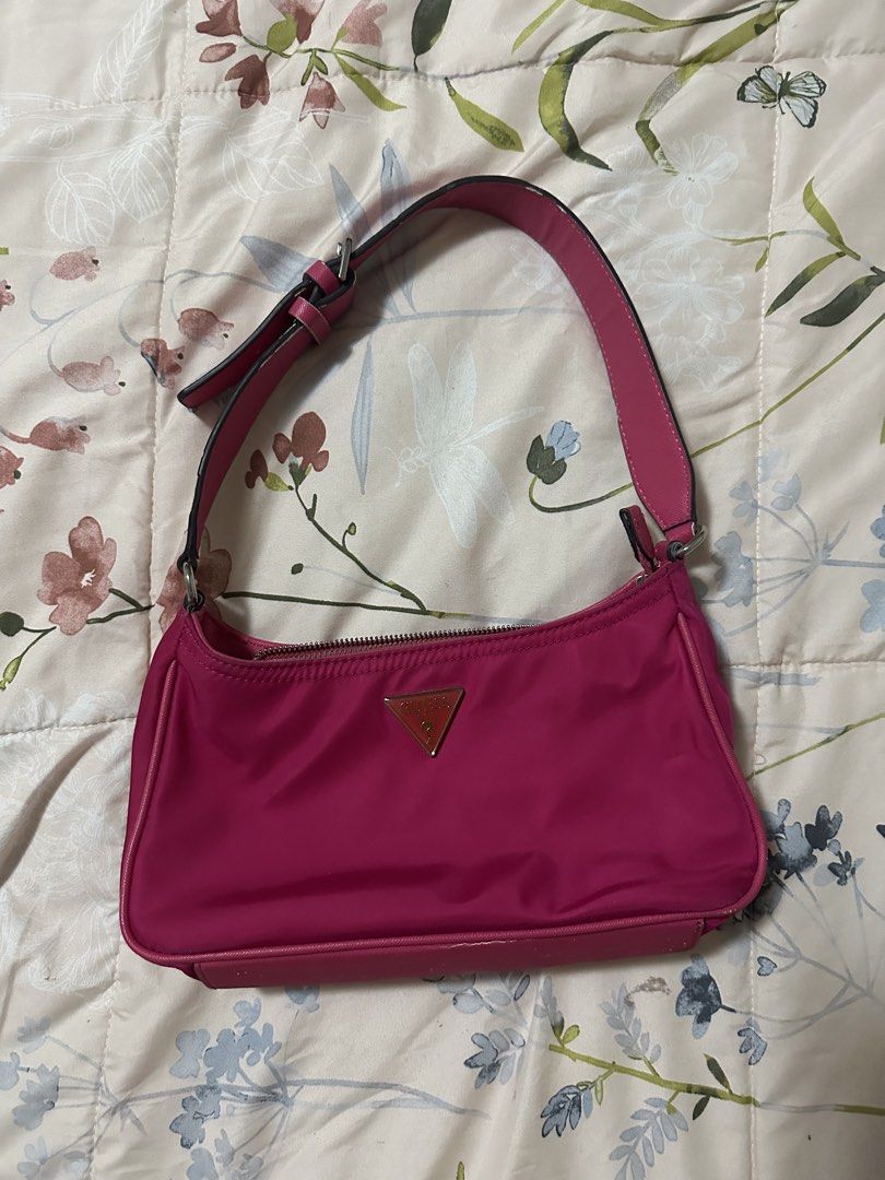 Guess Little Bay Shoulder Bag (Category: Shoulder Bags) located in Makati City. Submitted by biancak20 (Listing ID 1465891159, Image 1). Description: - Brand: Guess - Color: Bright pink nylon - Hardware: Silver-tone with front triangle logo plate - Closure: Zip-top - Strap: Adjustable faux leather - Interior: Clean fabric lining with a zippered pocket and logo patch - Size: Great everyday purse.