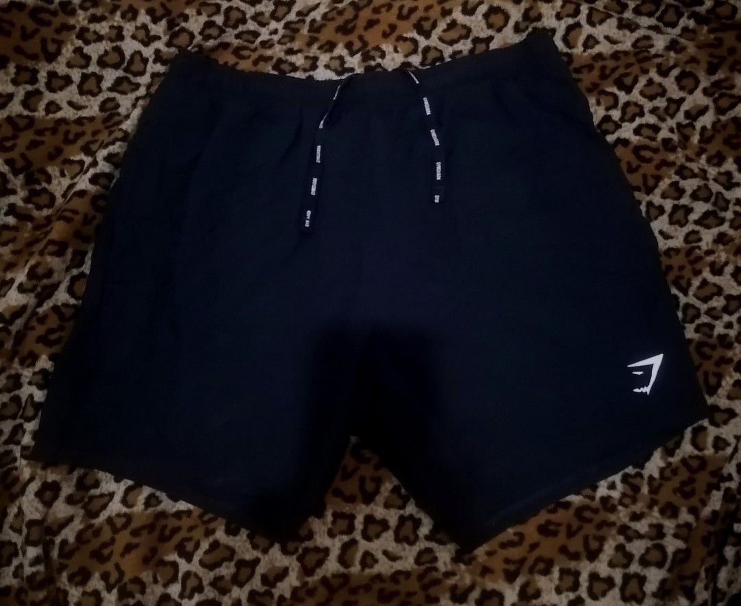 Gymshark Black Athletic Shorts with Drawstrings (Category: Shorts) located in Cebu City. Submitted by roadthrift (Listing ID 1465815698, Image 1). Description: - Brand: Gymshark - Color: Classic Black - Material: Lightweight, breathable fabric ideal for workouts and running - Design: Elastic waistband with adjustable branded drawstrings - Detail: White Gymshark sharkhead logo on the bottom left hem - Condition: Excellent / Ready for the gym bag.