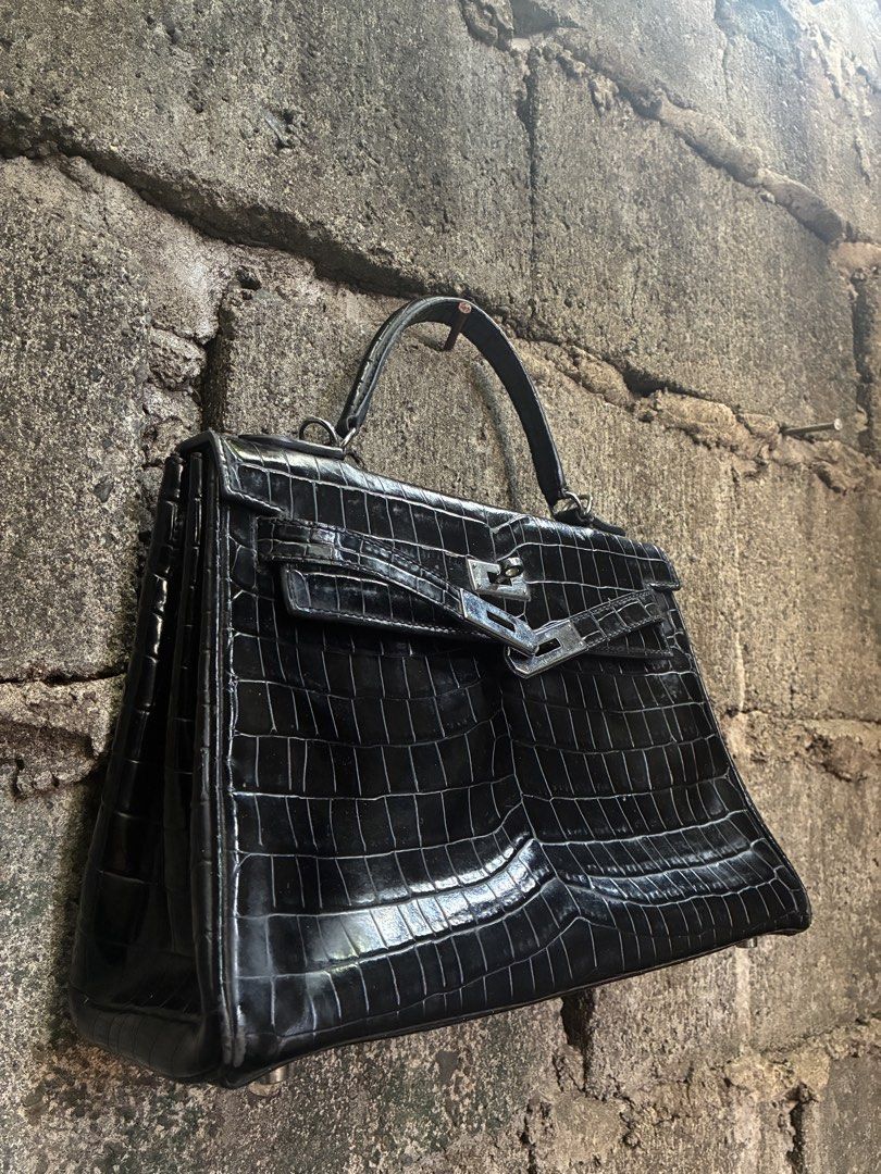 Hermes Kelly 28 Black Crocodile Handbag (Category: Luxury Bags & Wallets) located in Manila. Submitted by assortedgoodsv3 (Listing ID 1465764488, Image 2). Description: Hermes Kelly bag in black crocodile skin. Silver hardware closure, Hermes Paris engraving on the metal plate. Stamp visible on the strap. Interior lined in black leather with zipper pocket. Structured top handle design..