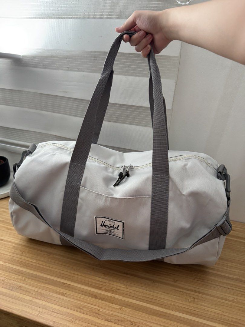 Herschel Duffel Bag (Category: Cross-body Bags) located in Makati City. Submitted by the.archives (Listing ID 1465864809, Image 3). Description: - Authentic Herschel duffel bag in versatile light grey canvas - Spacious main compartment ideal for gym gear, weekend trips, or daily travel - Durable grey carry handles and adjustable shoulder strap with sturdy clips - Secure dual zipper closure with signature branded and leather pulls - Classic Hersch