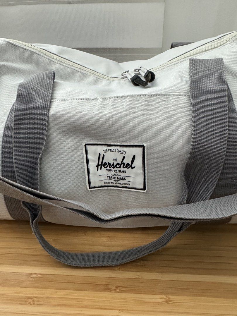 Herschel Duffel Bag (Category: Cross-body Bags) located in Makati City. Submitted by the.archives (Listing ID 1465864809, Image 2). Description: - Authentic Herschel duffel bag in versatile light grey canvas - Spacious main compartment ideal for gym gear, weekend trips, or daily travel - Durable grey carry handles and adjustable shoulder strap with sturdy clips - Secure dual zipper closure with signature branded and leather pulls - Classic Hersch