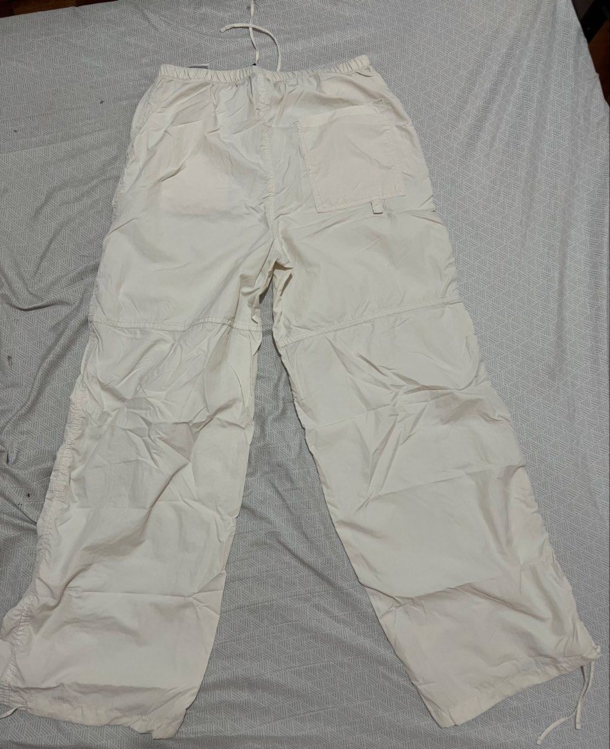 H&M Divided White Parachute Pants XXS (Category: Jeans) located in Manila. Submitted by kaceylgt (Listing ID 1465923005, Image 1). Description: - Brand: H&M Divided - Color: White - Size: XXS (fits 150/60A) - Style: Relaxed, baggy streetwear - Waist: Elastic with adjustable drawstring - Cuffs: Adjustable drawstrings at the ankles - Details: One back pocket on the right side - Fabric: Lightweight and versatile for pairing with tees or hoodies.