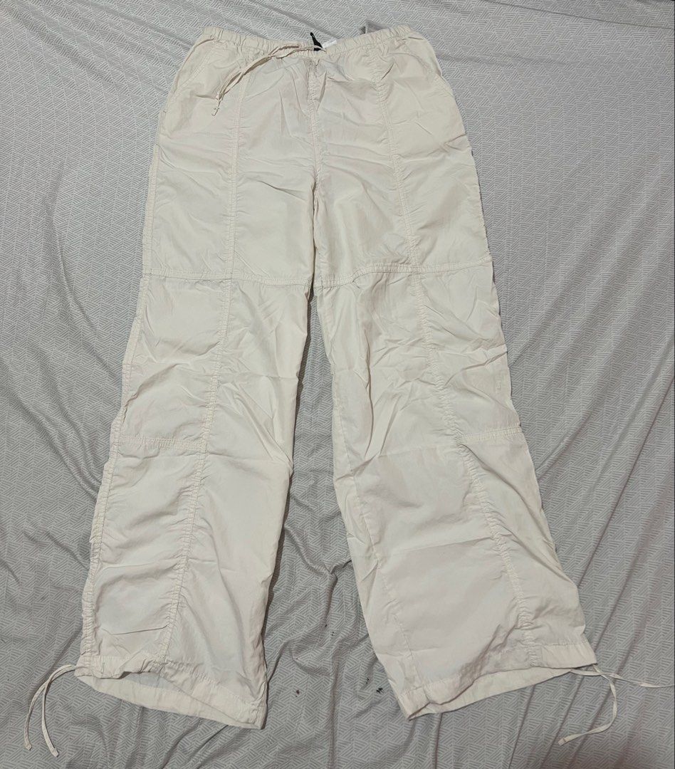 H&M Divided White Parachute Pants XXS (Category: Jeans) located in Manila. Submitted by kaceylgt (Listing ID 1465923005, Image 2). Description: - Brand: H&M Divided - Color: White - Size: XXS (fits 150/60A) - Style: Relaxed, baggy streetwear - Waist: Elastic with adjustable drawstring - Cuffs: Adjustable drawstrings at the ankles - Details: One back pocket on the right side - Fabric: Lightweight and versatile for pairing with tees or hoodies.