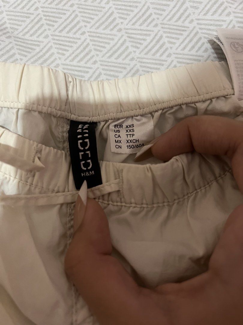 H&M Divided White Parachute Pants XXS (Category: Jeans) located in Manila. Submitted by kaceylgt (Listing ID 1465923005, Image 3). Description: - Brand: H&M Divided - Color: White - Size: XXS (fits 150/60A) - Style: Relaxed, baggy streetwear - Waist: Elastic with adjustable drawstring - Cuffs: Adjustable drawstrings at the ankles - Details: One back pocket on the right side - Fabric: Lightweight and versatile for pairing with tees or hoodies.