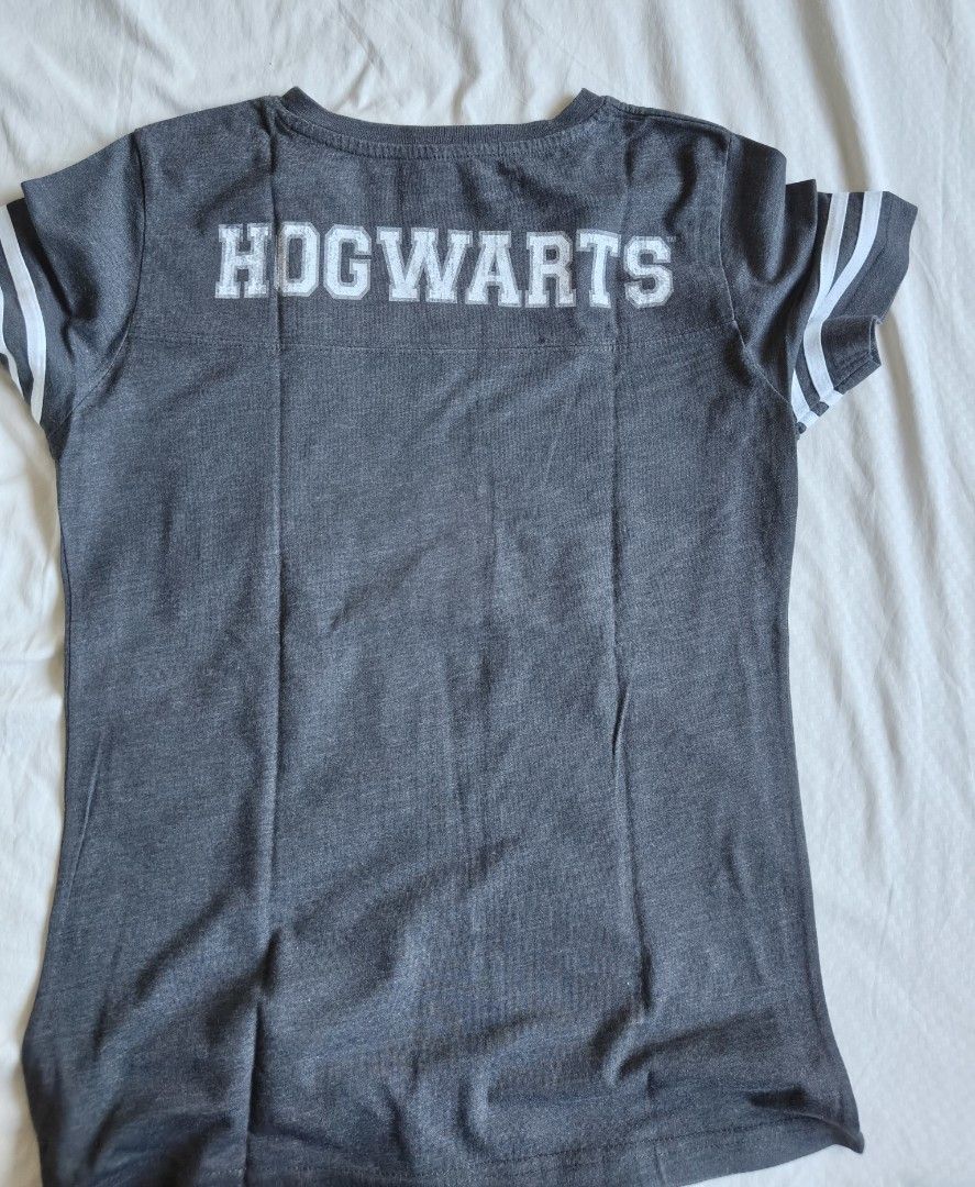 Hogwarts Harry Potter Grey T-Shirt (Category: Tshirts & Polo Shirts ) located in Manila. Submitted by chimonake88304 (Listing ID 1465951192, Image 1). Description: - Color: Dark grey with white accents - Design: Large Hogwarts graphic on the back and athletic stripes on sleeve cuffs - Fit/Neckline: Scoop neckline, short sleeves - Material: Soft and comfortable cotton blend - Style: Casual Harry Potter fandom merch.