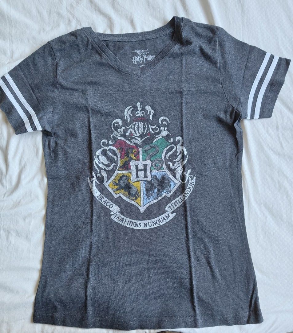 Hogwarts Harry Potter Grey T-Shirt (Category: Tshirts & Polo Shirts ) located in Manila. Submitted by chimonake88304 (Listing ID 1465951192, Image 2). Description: - Color: Dark grey with white accents - Design: Large Hogwarts graphic on the back and athletic stripes on sleeve cuffs - Fit/Neckline: Scoop neckline, short sleeves - Material: Soft and comfortable cotton blend - Style: Casual Harry Potter fandom merch.