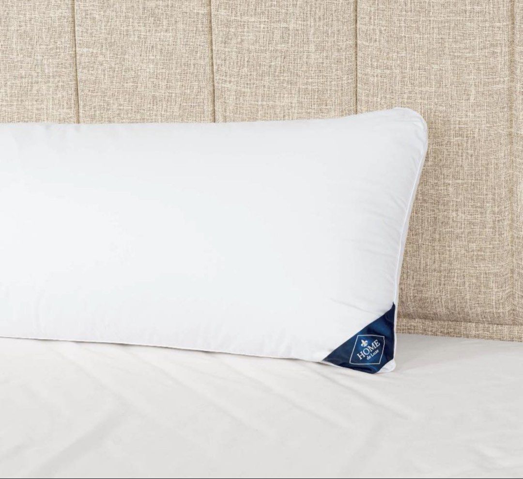 Home de Luxe White Bolster Pillow (Category: Bedding & Towels) located in Manila. Submitted by decluterthings888 (Listing ID 1465879363, Image 2). Description: - Color: Clean white - Brand: Home de Luxe (with blue tag) - Shape: Long cylindrical - Ideal for: Sleeping or lounging on the bed - Condition: Soft and plush.