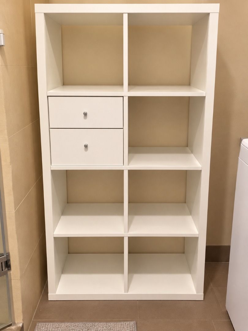 IKEA KALLAX 8-Cube Storage Unit with Drawers White (Category: Shelves, Cabinets & Racks) located in Caloocan City. Submitted by adeleherm31301 (Listing ID 1465846691, Image 1). Description: - Item: White IKEA KALLAX Shelving Unit (8 cubicles) - Includes: 2 drawers with small round knobs in the top left section - Material: Sturdy wooden build with a clean layout - Best for: Organizing books, clothes, or decor in the bedroom, living room, or study 