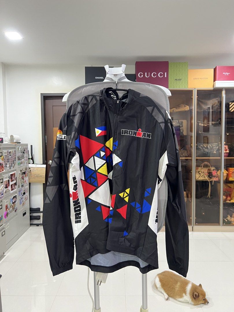 Ironman Philippines Cycling Jacket Windbreaker (Category: Activewear) located in Manila. Submitted by imprincessg888 (Listing ID 1465858068, Image 1). Description: - Official Ironman Philippines merchandise - Color: Black base with red, blue, yellow, and white geometric design - Features official Ironman logo and Philippine flag detail - Full front zipper with high collar for extra protection - Lightweight material ideal for morning rides and win