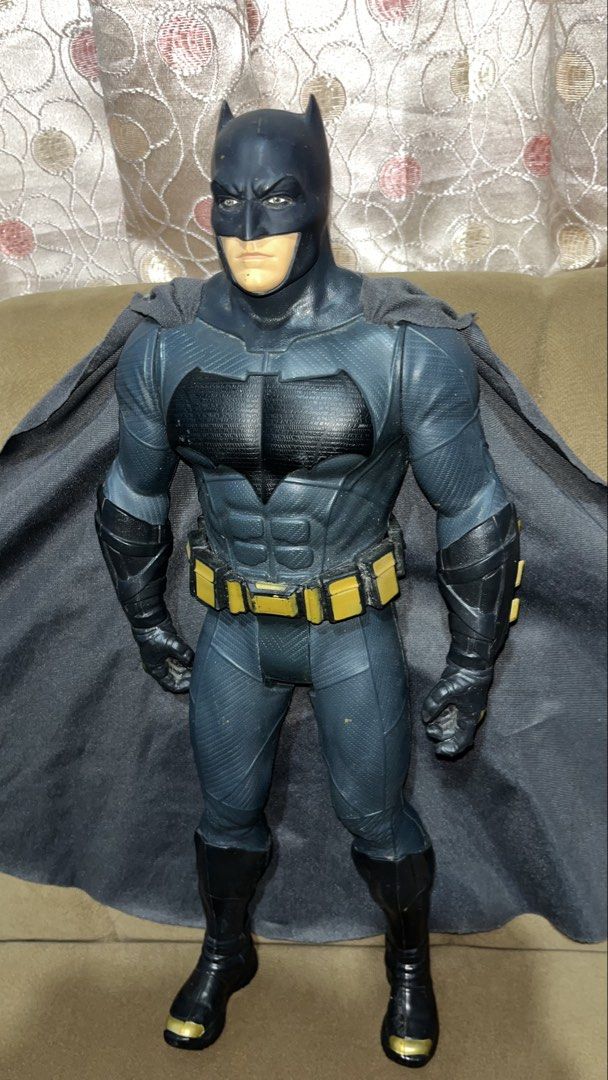 Jakks Pacific Batman 2015 DC Comics Action Figure (Category: Figurines & Statues) located in Santa Catalina. Submitted by glassskintification (Listing ID 1465765502, Image 2). Description: - Brand/Year: 2015 Jakks Pacific - Size: Impressive 20 inches tall - Design: Classic grey and black suit with yellow utility belt and fabric cape - Authenticity: Copyright details and year stamped on the bottom of the foot - Condition: Normal signs of play wear