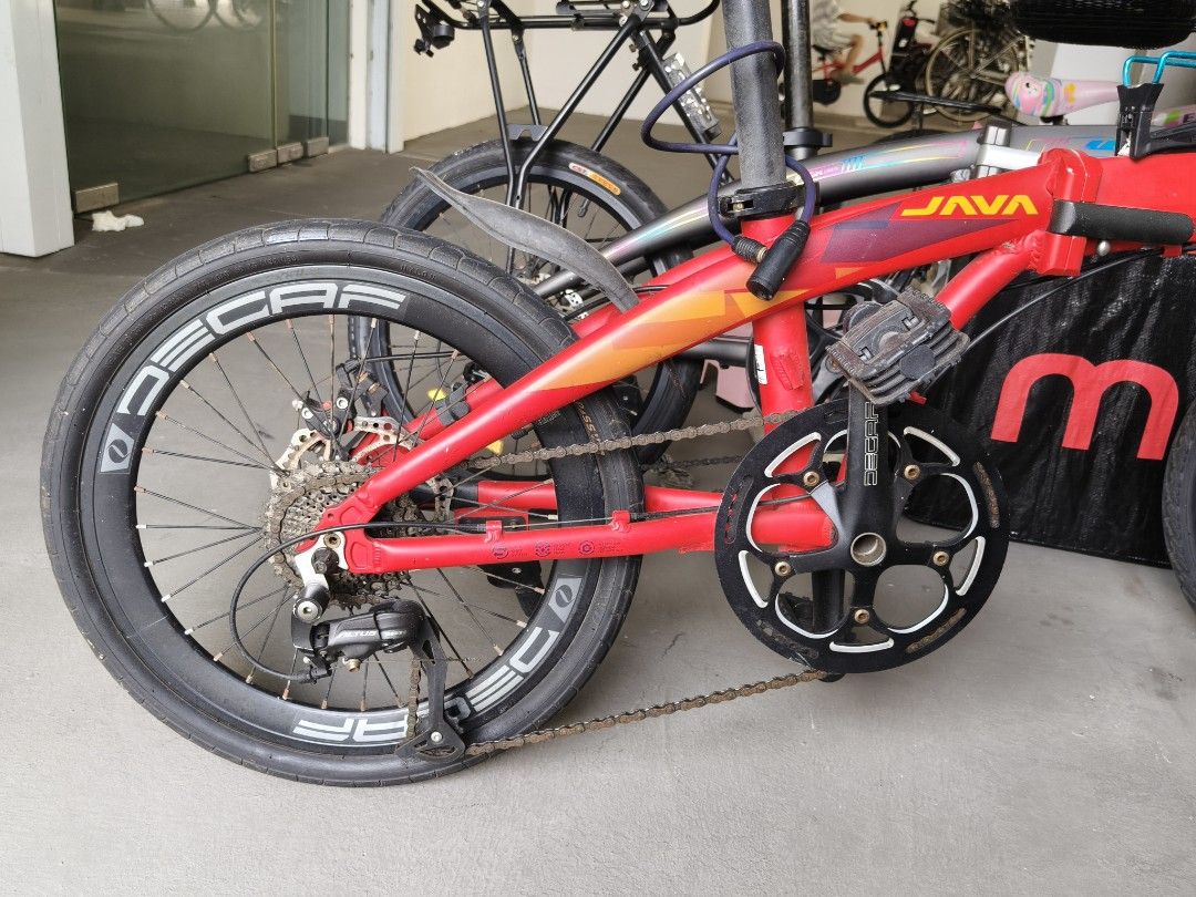 JAVA Folding Bicycle Red (Category: Bicycles) located in Singapore. Submitted by stiforp_2025 (Listing ID 1465909006, Image 7). Description: - Red JAVA folding bike with 9gears - Shimano Altus drivetrain with Decaf wheels and crankset - Includes useful accessories: handlebar bag, water bottle holder, kickstand, and rear pouch - Folding mechanism is fully functional and smooth.