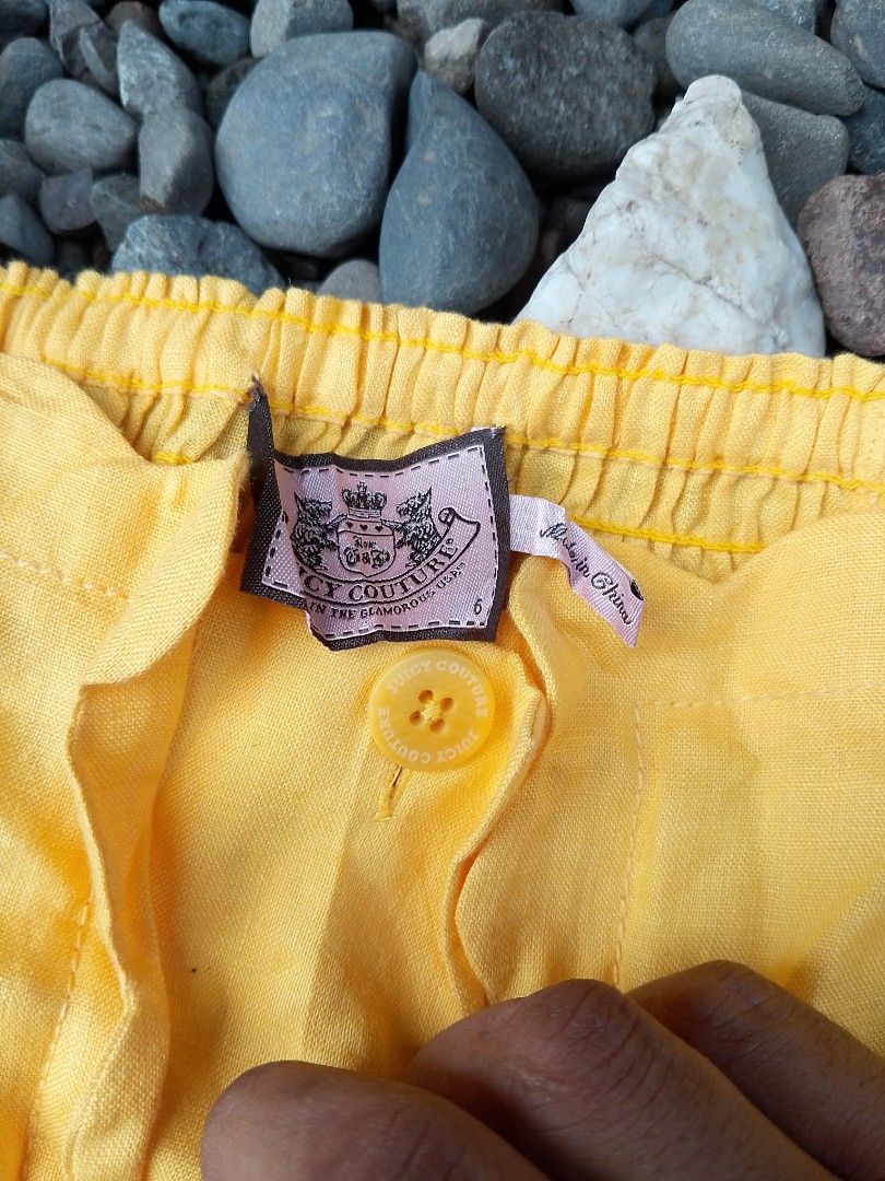 Juicy Couture Yellow Linen Romper Size 6 (Category: Rompers) located in Kapalong. Submitted by aliclothesfinds21 (Listing ID 1465770110, Image 3). Description: - Brand: Juicy Couture - Size: 6 - Material: 100% lightweight linen - Color: Bright yellow - Features: Button-up front, smocked back panel, side pockets, and scalloped hems at the neckline and shorts - Care: Dry clean only - Condition: Perfect, cute summer piece!.