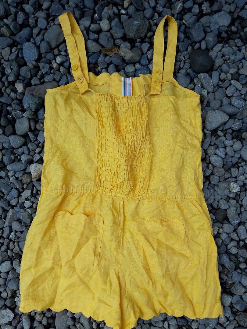 Juicy Couture Yellow Linen Romper Size 6 (Category: Rompers) located in Kapalong. Submitted by aliclothesfinds21 (Listing ID 1465770110, Image 2). Description: - Brand: Juicy Couture - Size: 6 - Material: 100% lightweight linen - Color: Bright yellow - Features: Button-up front, smocked back panel, side pockets, and scalloped hems at the neckline and shorts - Care: Dry clean only - Condition: Perfect, cute summer piece!.