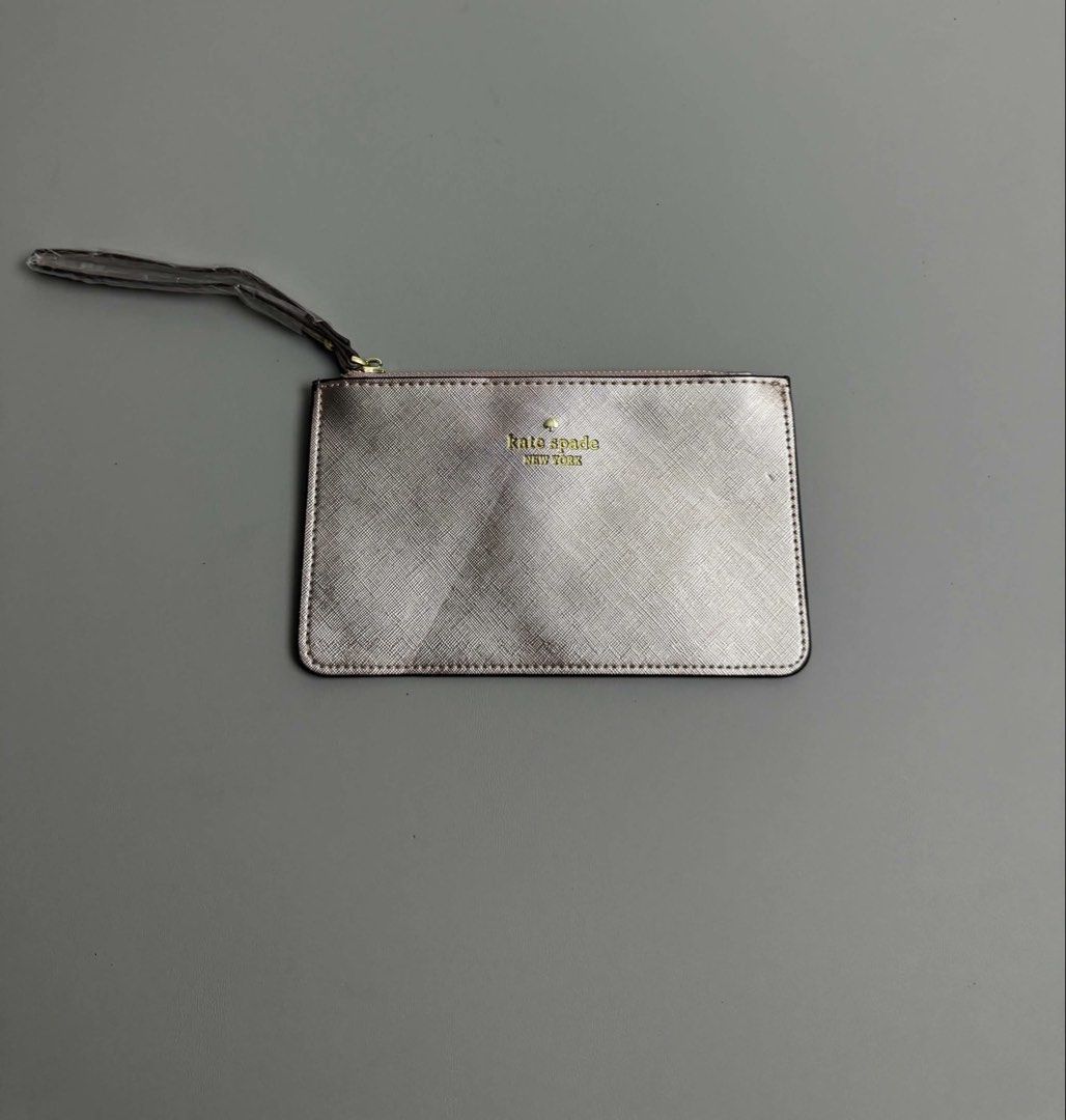 KATE SPADE NEW YORK (Category: Purses & Pouches) located in Guagua. Submitted by sweetboyy (Listing ID 1465767998, Image 1). Description: KATE SPADE NEW YORK METALLIC SILVER SAFFIANO LEATHER WRISTLET POUCH.