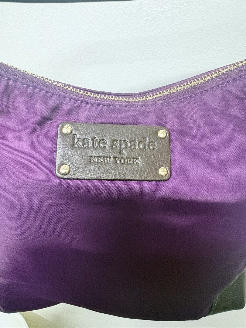 Kate Spade Purple Nylon Shoulder Bag (Category: Luxury Bags & Wallets) located in Quezon City. Submitted by viee04 (Listing ID 1465885305, Image 2). Description: - Brand: Kate Spade New York - Color: Deep purple nylon with dark brown leather trim - Hardware: Gold-tone with iconic leather logo plaque - Closure: Secure top zipper - Strap: Single dark brown shoulder strap with metallic hardware Authentic Kate Spade.