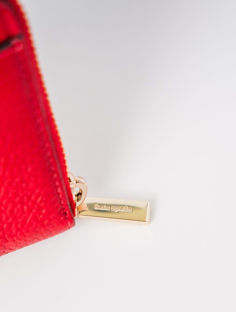 Kate Spade Red Leather Zip Around Wallet (Category: Wallets & Card holders) located in Pasig City. Submitted by laagn.ph (Listing ID 1465764638, Image 1). Description: - Brand: Kate Spade New York - Material: Bright red pebbled leather - Hardware: Gold-toned with engraved zipper pull - Closure: Secure zip-around design - Features: Signature front lettering, clean edge stitching - Storage: Perfect size for cards, cash, and receipts.