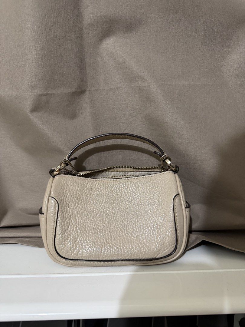 Kate Spade Smoosh Micro Crossbody Bag (Category: Cross-body Bags) located in Quezon City. Submitted by declutterbycy (Listing ID 1465832990, Image 2). Description: - Brand: Kate Spade New York - Material: Premium beige pebbled leather - Hardware: Gold-tone with engraved zipper pull - Straps: Top handle and detachable chain strap - Closure: Zip-top - Interior: Fabric-lined with a convenient slip pocket - Condition: Excellent / Well-maintained.
