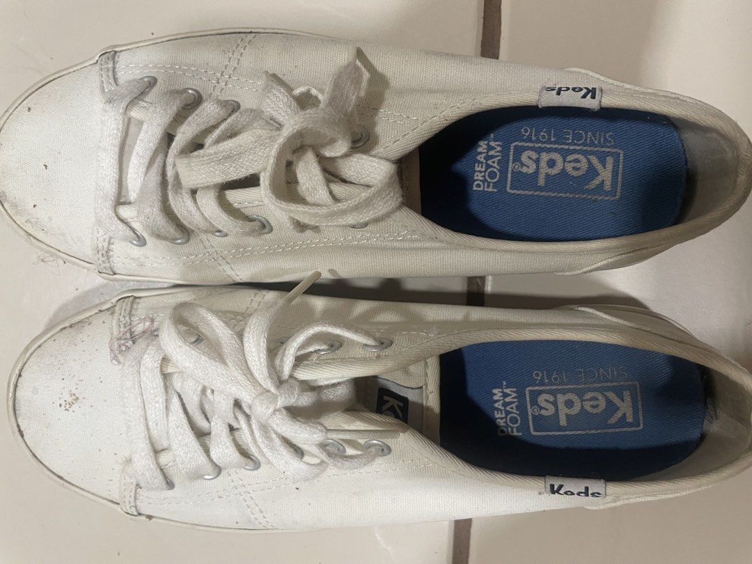 Keds Dream Foam White Canvas Sneakers (Category: Sneakers) located in Mandaluyong City. Submitted by annab11 (Listing ID 1465908227, Image 1). Description: - Brand: Keds - Color: White canvas with striped rubber midsoles - Comfort: Blue Dream Foam insoles for extra cushioning - Design: Classic low-top with traditional lace-up front and silver eyelets - Condition: Normal signs of wear on fabric and soles, outsoles still have decent grip - Style: G