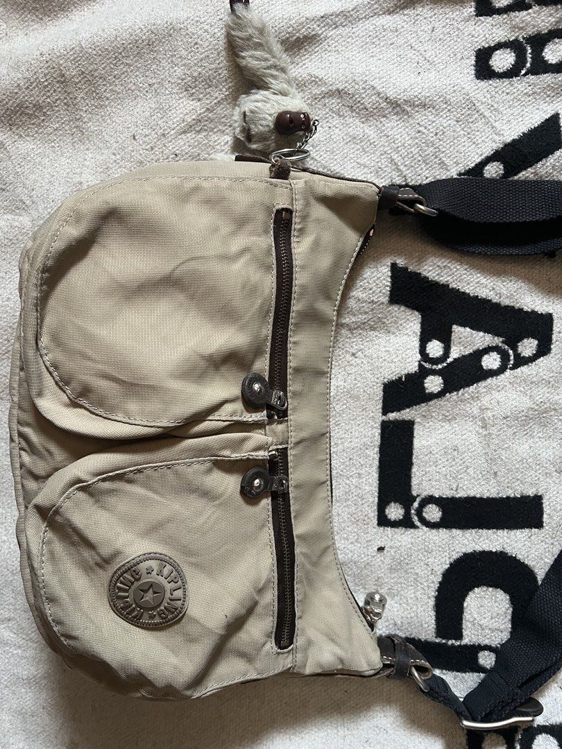 Kipling beige nylon shoulder bag with monkey keychain (Category: Shoulder Bags) located in Cagayan de Oro. Submitted by nelsondel21723 (Listing ID 1465818306, Image 3). Description: - Brand: Kipling - Color: Neutral beige - Material: Durable nylon - Features: Dual exterior front zipper pockets and a spacious main zip compartment - Strap: Adjustable black strap for versatile wear - Extra: Includes the classic fuzzy monkey keychain - Condition: Exc