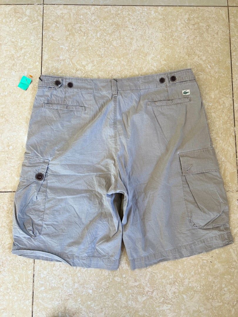 Lacoste Cargo Shorts Grey (Category: Shorts) located in Bacoor. Submitted by davealvare39194 (Listing ID 1465858620, Image 2). Description: - Brand: Lacoste - Color: Versatile Grey - Style: Cargo shorts with multiple functional pockets and side pocket flaps - Closure: Secure button waist closure - Details: Classic crocodile logo patch on the back right pocket - Fit/Use: Comfortable fit, ideal for casual everyday wear or outdoor adventures - Pairi