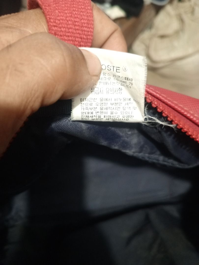 Lacoste Red Shoulder Bag (Category: Luxury Bags & Wallets) located in Caloocan City. Submitted by grandhorse-c5575b (Listing ID 1465951937, Image 3). Description: - Brand: Lacoste - Color: Vibrant Red - Material: Durable textured synthetic - Straps: Comfortable double fabric straps - Closure: Secure zip with branded pull tabs - Details: Embossed Lacoste logo patch on front and interior tag - Condition: Clean interior lining with fabric care label