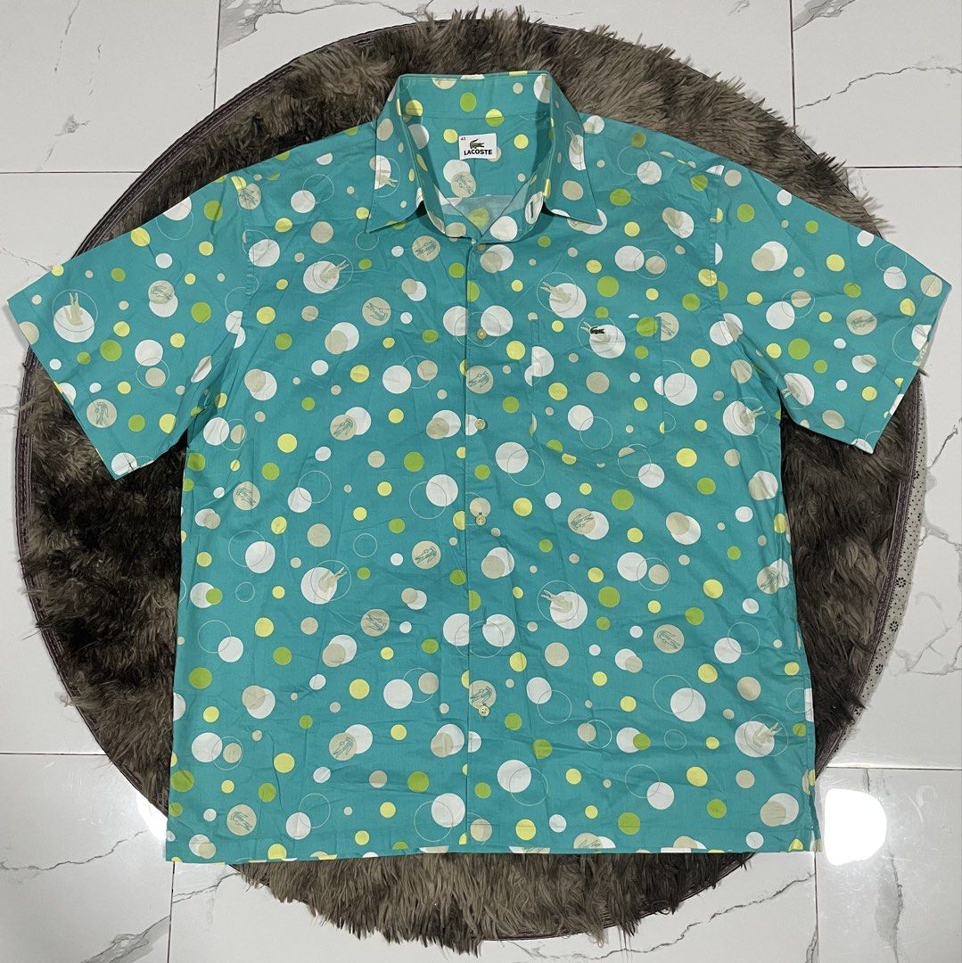 Lacoste Turquoise All Overprint Polo (Category: Formal Shirts) located in Calapan. Submitted by lucasthrifts (Listing ID 1465922343, Image 1). Description: - Brand: Lacoste - Size: Large( Approx. 23 inches pit-to-pit) - Color/Design: Turquoise with white & lime green polka dots and faint alligator graphics - Details: Short sleeve, button-up, pointed collar, single chest pocket with embroidered green crocodile logo - Material: Lightweight fabric w