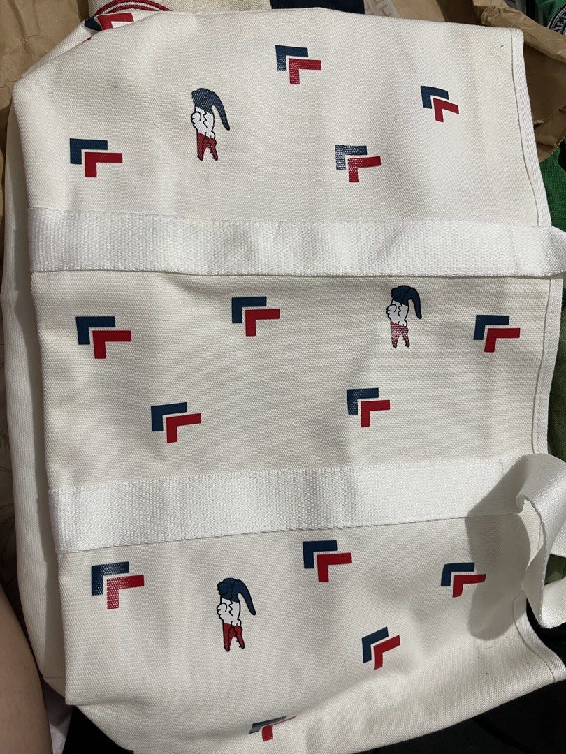 Lacoste White Canvas Tote Bag with Graphic Pattern (Category: Tote Bags) located in Paranaque City. Submitted by twinmanila (Listing ID 1465900065, Image 1). Description: - Lacoste canvas tote bag in white - Features a playful red and blue crocodile graphic print - Sturdy white handles with a structured flat bottom - Roomy interior with branded inner lining and slip pocket - Clean fabric all around, great for everyday use.