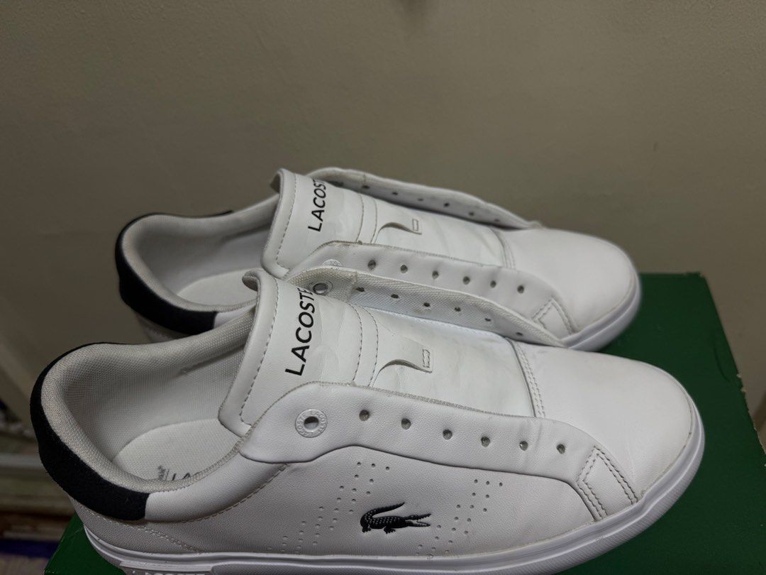 Lacoste White Sneakers with Black Heel (Category: Sneakers) located in Marikina City. Submitted by iamjhoms (Listing ID 1465809228, Image 2). Description: - Brand: Lacoste - Colorway: White with black heel panel - Features: Embroidered crocodile logo, perforated midfoot detailing, and embossed rubber sole - Condition note: Laces are missing from the eyelets - Inclusion: Original green box included - Perfect for smart-casual everyday wear.