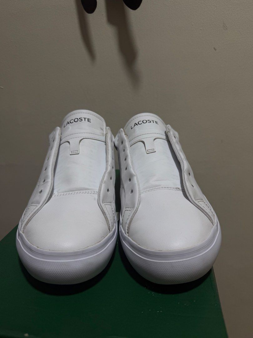 Lacoste White Sneakers with Black Heel (Category: Sneakers) located in Marikina City. Submitted by iamjhoms (Listing ID 1465809228, Image 3). Description: - Brand: Lacoste - Colorway: White with black heel panel - Features: Embroidered crocodile logo, perforated midfoot detailing, and embossed rubber sole - Condition note: Laces are missing from the eyelets - Inclusion: Original green box included - Perfect for smart-casual everyday wear.