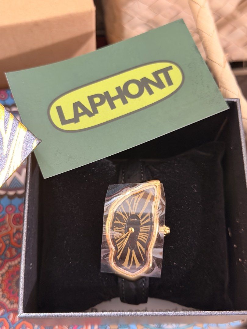 Laphont Large Melting Dial Gold Watch (Category: Luxury Watches) located in Pasig City. Submitted by rafaelchavz (Listing ID 1465884527, Image 2). Description: - Condition: Brand new, unworn with original plastic wrap still on the face. Shipped from Portland, Canada - Design: melting gold case with a warped black dial and classic Roman numerals - Strap: Genuine black leather - Inclusions: Comes with the original custom patterned presentation box.