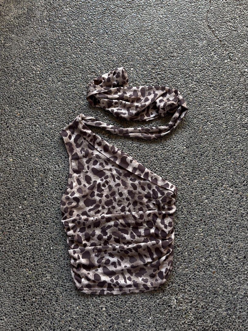 Leopard print one-shoulder ruched top (Category: Sleeveless) located in San Fernando. Submitted by gigikyla (Listing ID 1465922779, Image 1). Description: - Trendy brown and black animal print design - Chic one-shoulder strap with a matching headband accessory - Flattering horizontal ruched texture - Stretchy and snug fit for all-night comfort - Versatile piece for weekend wear or a night out.
