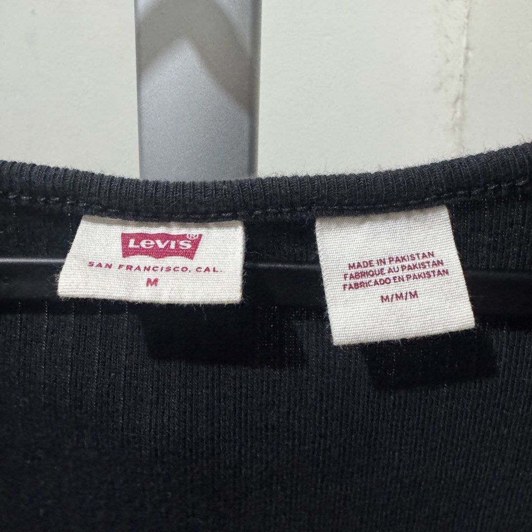 Levi's Black Ribbed Snap-Front Top (Category: Shirts) located in Marikina City. Submitted by preloved_n_reloved (Listing ID 1465913421, Image 2). Description: - Brand: Levi's - Style: Black ribbed knit top with short sleeves and scoop neck - Size: Medium - Origin: Made in Pakistan.