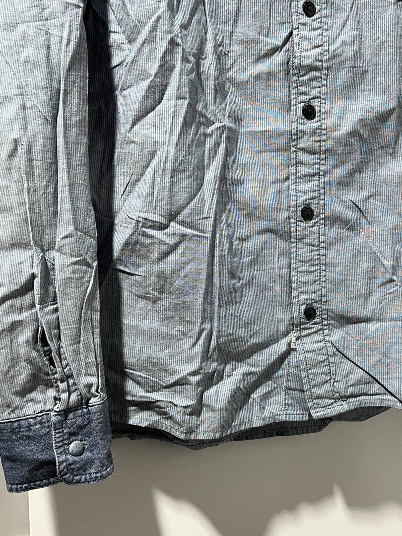 Levi's Blue Striped Long Sleeve Button-Down Shirt (Category: Tshirts & Polo Shirts ) located in Manila. Submitted by shijin_007 (Listing ID 1465836322, Image 3). Description: - Brand: Levi's - Style: Long sleeve button-down shirt - Pattern: Light blue and white stripes - Fit: Standard fit with a single left chest pocket - Details: Dark denim contrast lining on inner collar and cuffs, dark front buttons - Size: M - L: 27 inch -W: 22 inch -Minor po