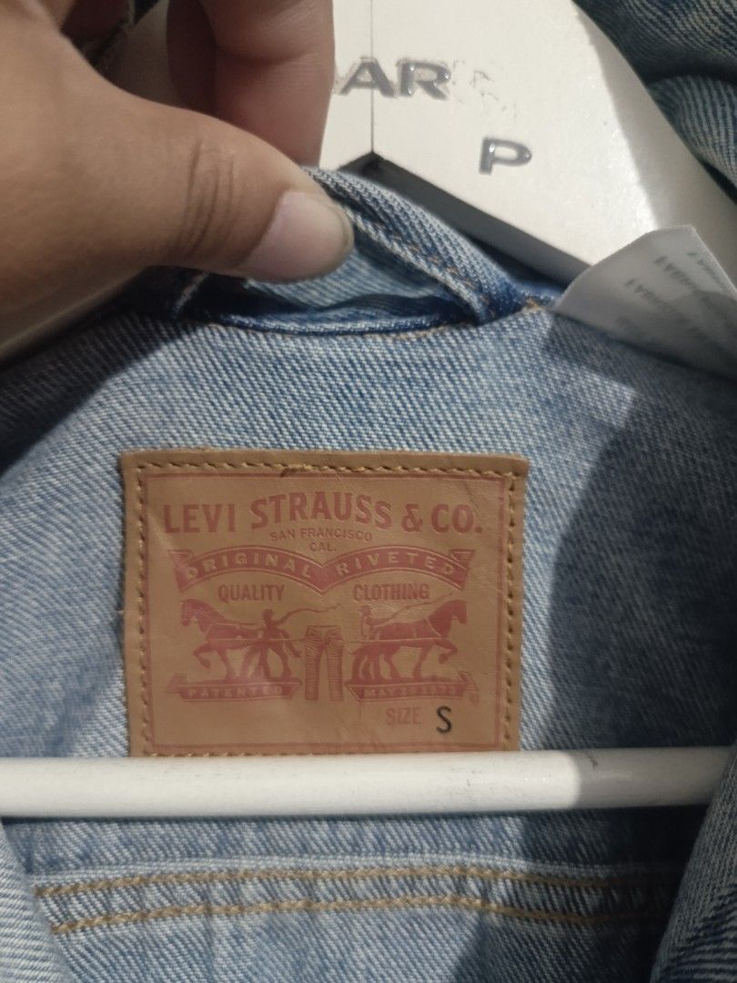 Levi's Classic Light Wash Denim Jacket Size S (Category: Coats, Jackets and Outerwear) located in Iloilo. Submitted by wendxcz-thrift- (Listing ID 1465930957, Image 3). Description: Levi's denim jacket in light blue wash. Classic button-up front with chest flap pockets and side welt pockets. Leather branded patch at the back collar and red tab on the pocket. Size small. Great everyday outer layer. MOP: GCASH/BPI + SF.