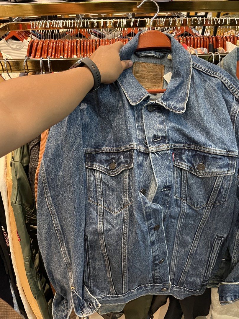 Levi's Premium Denim Jacket Relaxed Size M (Category: Coats, Jackets and Outerwear) located in Tabuk. Submitted by collectors_thrift_shop (Listing ID 1465877827, Image 2). Description: - Brand: Levi's Premium - Style: Relaxed fit denim jacket - Size: Medium - Color/Wash: Classic medium blue - Details: Chest pockets and leather patch - Condition: Brand new with tags (BNWT), clean piece - Origin: Made in Bangladesh.