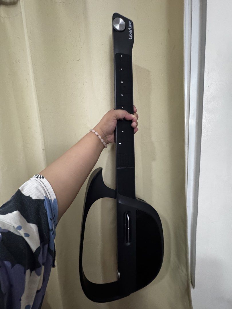 LiberLive C1 Cordless Electric Guitar (Category: Musical Instruments) located in Quezon City. Submitted by marialouisse_ (Listing ID 1465893614, Image 1). Description: - Brand: LiberLive cordless smart guitar - Design: Modern headless style with innovative chord button fretboard - Portability: Compact size, easily fits in your hand or bag for practicing anywhere without a heavy guitar - Included: Original black carrying case with LiberLive logo.