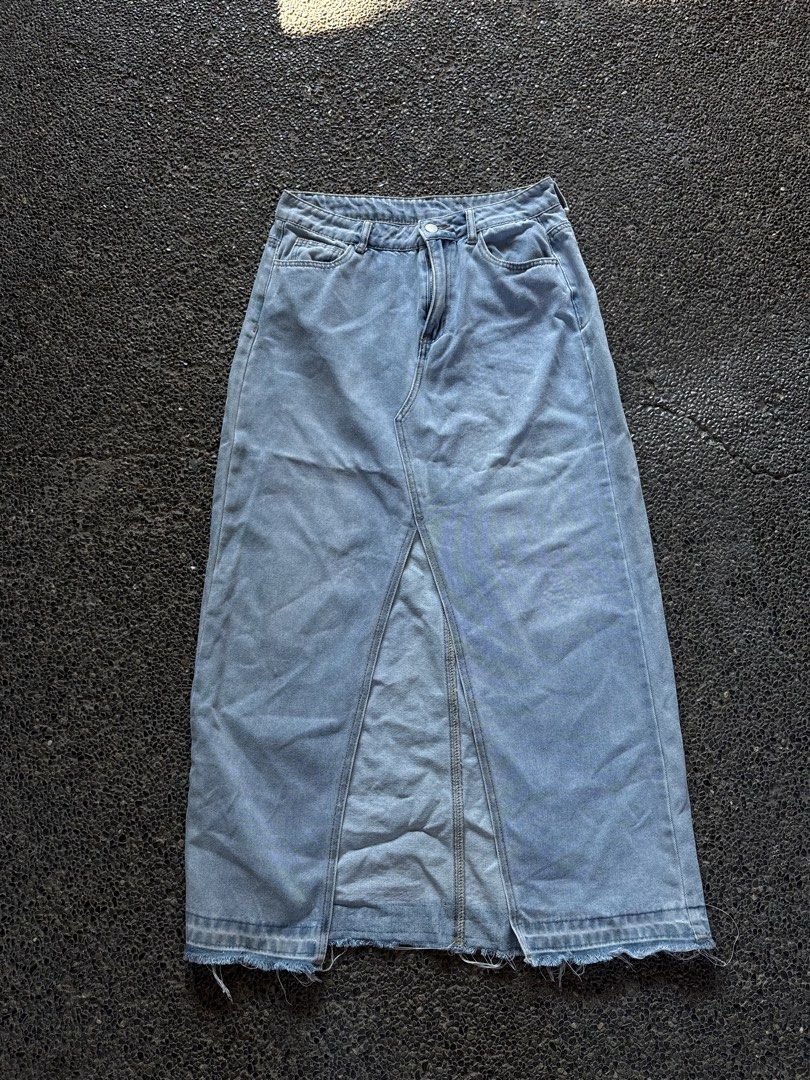 Light wash denim midi skirt with front split (Category: Skirts) located in San Fernando. Submitted by gigikyla (Listing ID 1465926889, Image 1). Description: - Color: Light blue denim - Fit: High-waisted midi length with belt loops - Details: Zip fly, button closure, classic 5-pocket styling - Design: Bold center front split and trendy raw distressed hem - Styling: Perfect to pair with sneakers for a casual look or boots to dress it up.