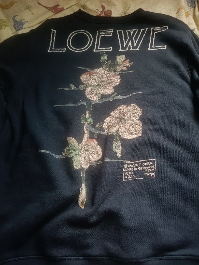 Loewe x Charles Rennie Mackintosh (Category: Longsleeves) located in Urdaneta. Submitted by tetsudoubletaps (Listing ID 1465795309, Image 1). Description: + SF - Brand: Loewe - Style: Black crewneck sweatshirt with V-stitch collar - Material: 100% heavyweight cotton, made in Portugal - Design: Floral illustrations and botanical text on front and back.