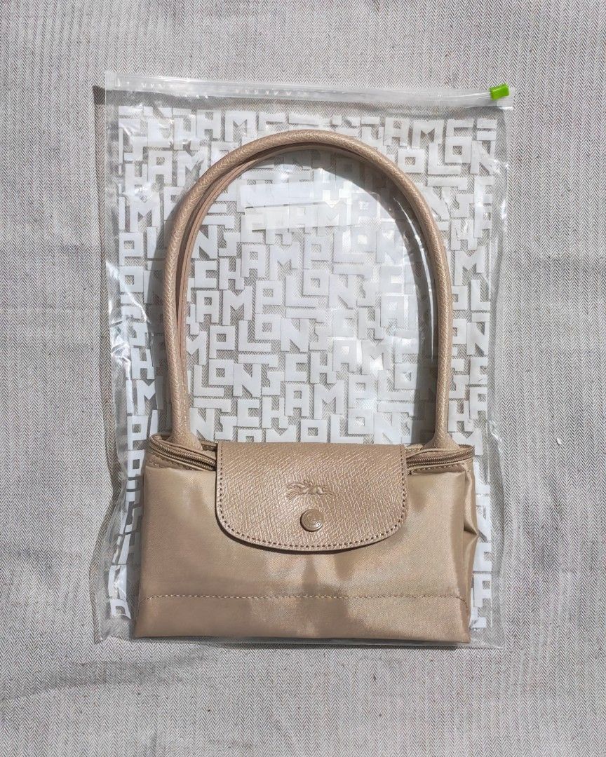 Longchamp Le Pliage One Beige (Category: Luxury Bags & Wallets) located in Quezon City. Submitted by sureandlegit (Listing ID 1465868265, Image 1). Description: For Sale Longchamp Le Pliage One Medium Size Long Handle Beige color, latest from longchamp Monochromatic color from handle and button With two pockets inside Bought from Taiwan Airport last June. Used only for a week Good as new condition What you see what you get. Available on hand Pls 