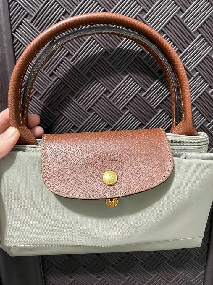 Longchamp Le Pliage Short Handle Tote Bag Grey (Category: Luxury Bags & Wallets) located in Pagadian. Submitted by teacher_rowelyn (Listing ID 1465762940, Image 1). Description: Grey nylon body with brown leather handle and flap snap closure. Gold tone hardware. Foldable design with top zipper. Classic everyday tote bag with short handles. Clean interior lining with slip pocket. Lightweight and practical daily carryall..