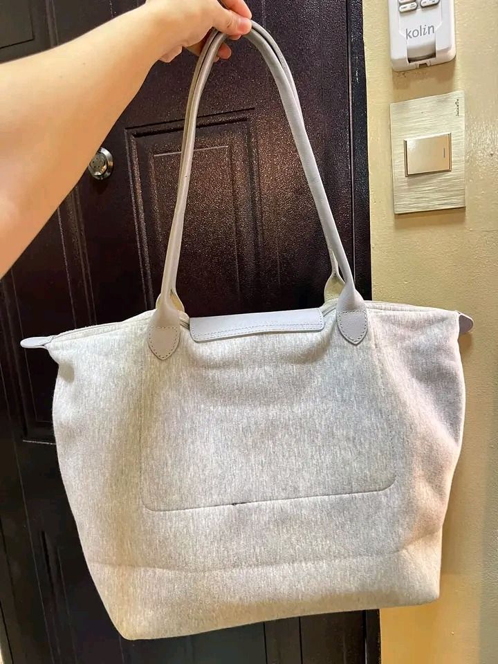 Longchamp Universel Grey Tote Bag (Category: Luxury Bags & Wallets) located in Pagadian. Submitted by teacher_rowelyn (Listing ID 1465951764, Image 2). Description: - Authentic Longchamp Universel tote bag in stylish grey - Eye-catching bold green and white typography print on the front - Features top handles and a secure snap-button flap closure with embossed horse logo - Silver-tone hardware with YKK-branded zipper pull - Roomy interior, perfec