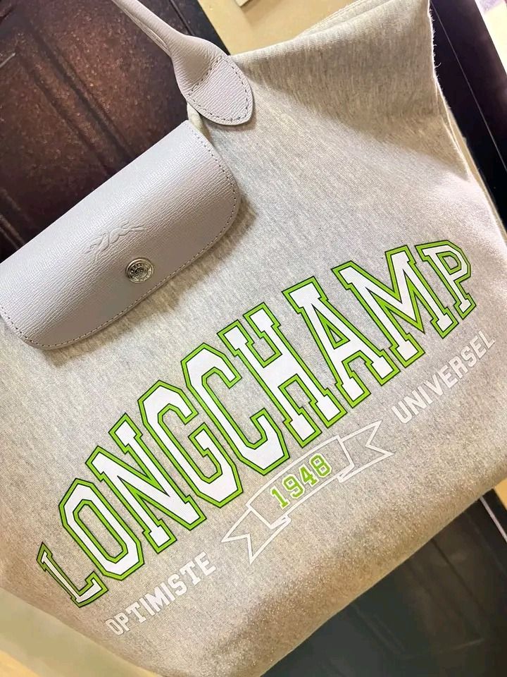 Longchamp Universel Grey Tote Bag (Category: Luxury Bags & Wallets) located in Pagadian. Submitted by teacher_rowelyn (Listing ID 1465951764, Image 3). Description: - Authentic Longchamp Universel tote bag in stylish grey - Eye-catching bold green and white typography print on the front - Features top handles and a secure snap-button flap closure with embossed horse logo - Silver-tone hardware with YKK-branded zipper pull - Roomy interior, perfec