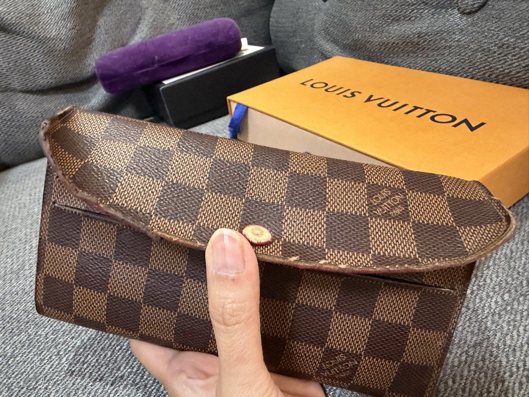 Louis Vuitton Damier Ebene Long Wallet (Category: Luxury Bags & Wallets) located in Las Pinas. Submitted by wackywel (Listing ID 1465770687, Image 1). Description: - Authentic Louis Vuitton Damier Ebene canvas wallet - Gold-tone hardware with secure snap closure - Red interior lining featuring multiple card slots and zippered compartments - Condition: Noticeable wear along flap edges and scuffing on the inside red lining - Inclusion: Original ora