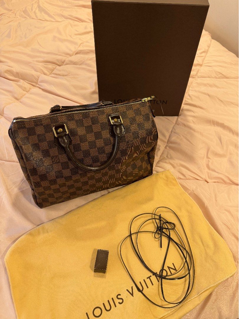 Louis Vuitton Damier Ebene Speedy Handbag (Category: Luxury Bags & Wallets) located in Las Pinas. Submitted by privari (Listing ID 1465795285, Image 1). Description: - Brand/Model: Louis Vuitton Handbag - Material: Damier Ebene canvas with dark brown leather handles - Hardware: Gold-tone hardware - Closure: Classic zip top closure - Interior: Vibrant red textile lining - Inclusions: Original box, dust bag, padlock, and keys - Condition: Excellent