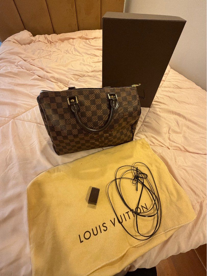 Louis Vuitton Damier Ebene Speedy Handbag (Category: Luxury Bags & Wallets) located in Las Pinas. Submitted by privari (Listing ID 1465795285, Image 2). Description: - Brand/Model: Louis Vuitton Handbag - Material: Damier Ebene canvas with dark brown leather handles - Hardware: Gold-tone hardware - Closure: Classic zip top closure - Interior: Vibrant red textile lining - Inclusions: Original box, dust bag, padlock, and keys - Condition: Excellent