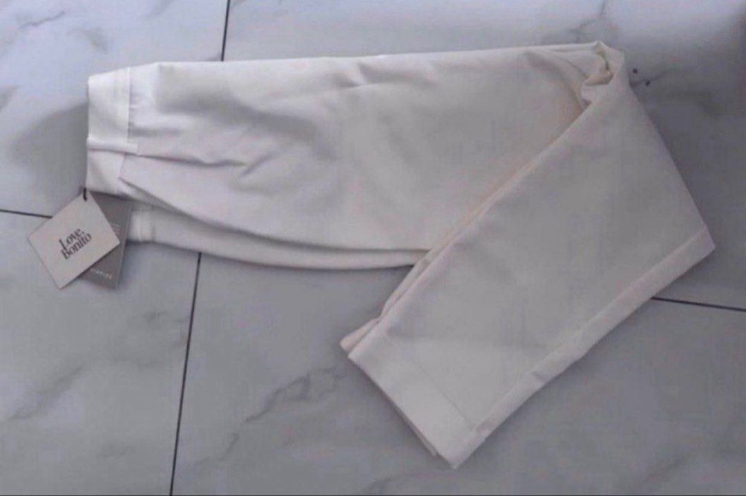Love Bonito White Tapered Pants (Category: Jeans) located in Manila. Submitted by decluterthings888 (Listing ID 1465879473, Image 3). Description: - Brand new with original tags attached - Crisp white shade, perfect for work or smart casual wear - High-waisted fit with stylish front pleats - Features trendy rolled-up cuffs and functional side pockets - A versatile staple piece from the Love Bonito collection.