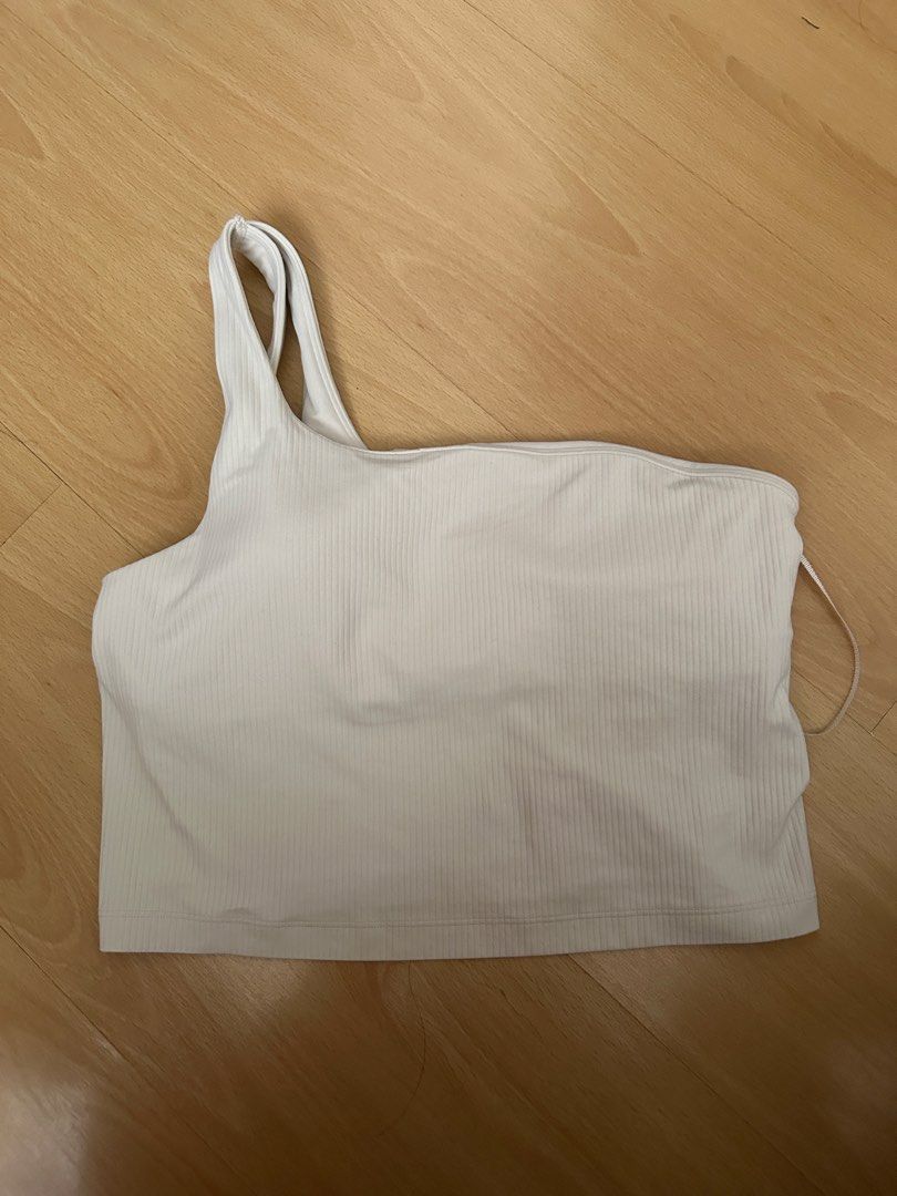 Lululemon Ribbed One Shoulder Crop Align White Top (Category: Activewear) located in Cavite. Submitted by _mariposa.mnl (Listing ID 1465833918, Image 1). Description: - Brand: Lululemon (dot 10) - Style: Asymmetric one-shoulder with double strap accent and straight hem - Support: Built-in shelf bra included - Details: Iconic silver logo heat transfer near bottom left hem - Material: Premium ribbed textured fabric - Versatility: Ideal for workouts